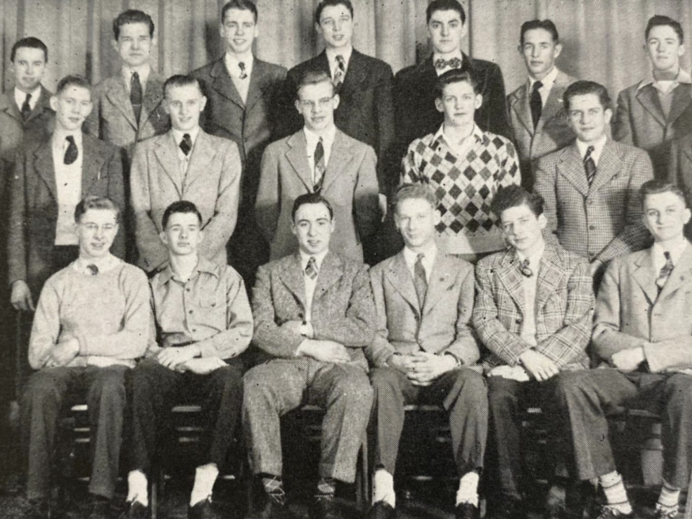 A historic black-and-white yearbook photo of a group of high school students, with Rich DeVos in the back row, second from right.